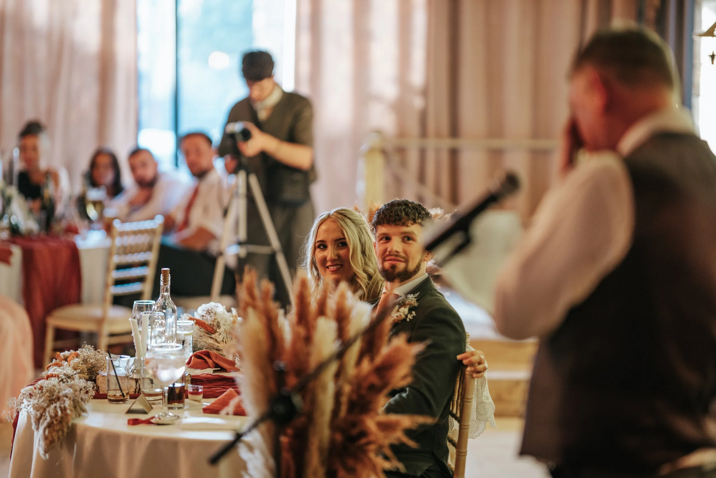 Loella and Gregg listening to wedding speeches