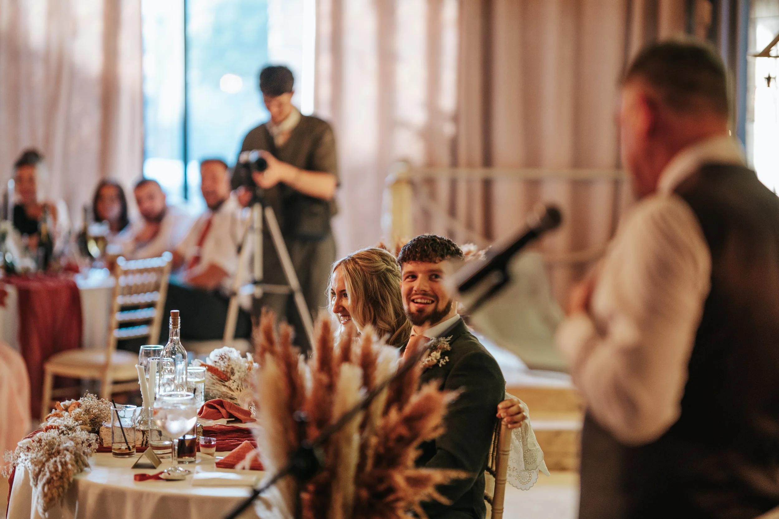 Loella and Gregg laughing during wedding speeches